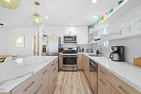 Prepare gourmet meals in this elegant kitchen, featuring a large island, modern appliances, and open shelving.