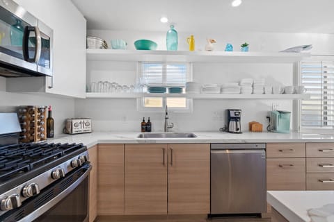 Prepare gourmet meals in this elegant kitchen, featuring a large island, modern appliances, and open shelving.
