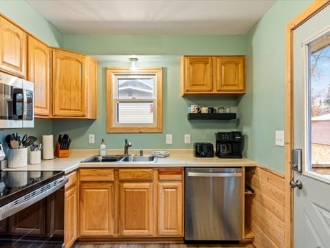 Fully equipped kitchen featuring wood cabinets and stainless steel refrigerator.