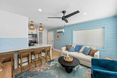 Cozy living room with a comfy sofa bed, perfect for relaxing with a sneak peek of the modern kitchen just beyond. A space that blends comfort and convenience!