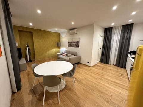 Spacious living room with kitchenette, round dining table with four chairs, sofa bed, balcony on Via Piol and SKY TV