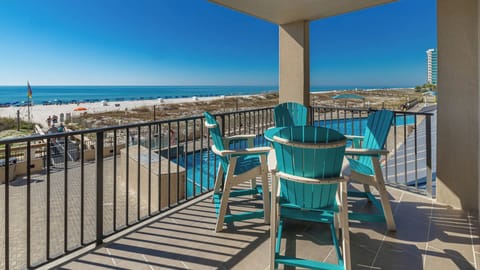 Relax in vibrant chairs on the balcony, enjoying views of the beach and pool area just steps away