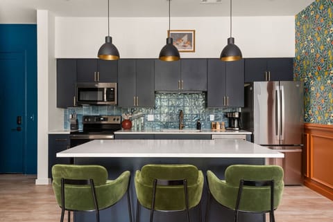 A stylish open-concept kitchen and living area with modern finishes, bold patterns, and colorful accents, creating a vibrant and welcoming atmosphere.