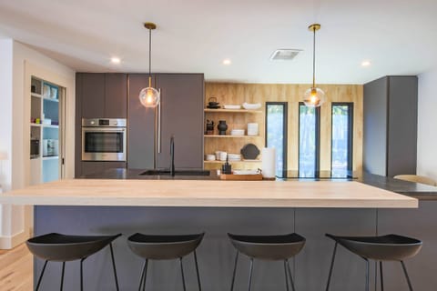The beautifully renovated kitchen features a central island with stool seating.