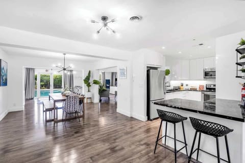 "Indoor elegance meets outdoor bliss—this Airbnb features a sleek kitchen, cozy lounge, and poolside views through glass doors."