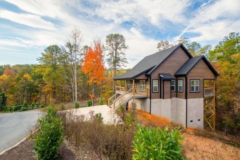 Charming wood cabin with a covered porch, nestled in a scenic forested setting.