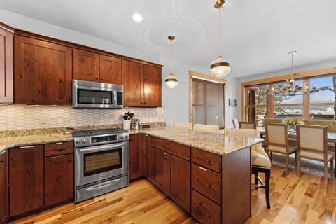 Full kitchen with stainless steel appliances, and breakfast bar seating 3.