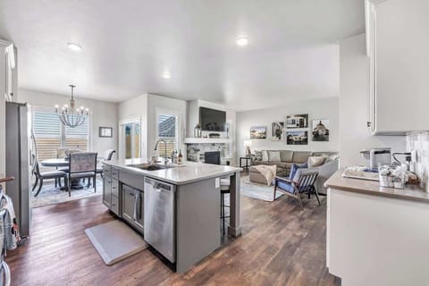 Fully equipped kitchen with pots/pans, utensils, place setting for 5 to 6 people, and modern appliances