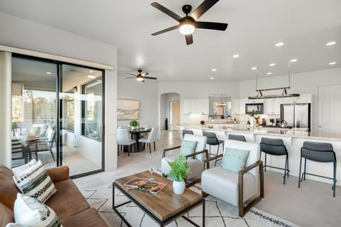 Living room with leather sofa, two chairs, open to kitchen and breakfast nook. Reflective 360 red rock view, Sliding glass door to the deck with dining and seating.