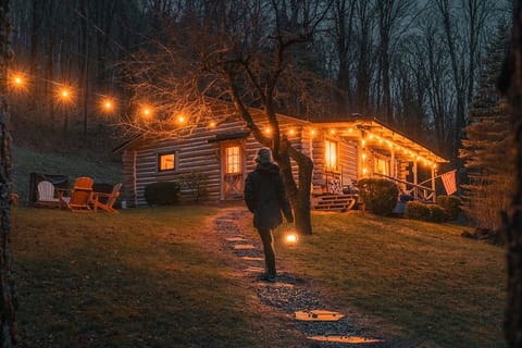 Magical nights under twinkling string lights — unwind by the fire or step inside to your glowing, rustic log cabin hideaway.