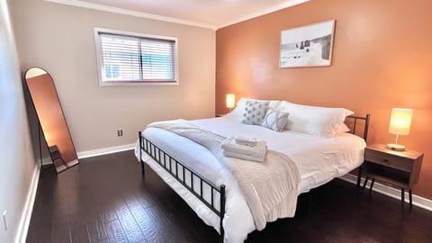 King bedroom w/ soft memory foam mattress, organic cotton bedding & full length mirror.