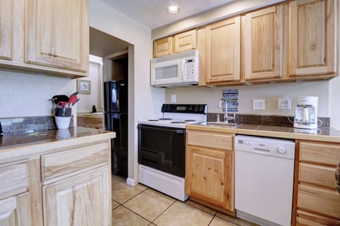 Kitchen area features a small dishwasher and coffee station.