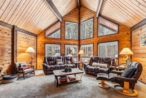 Living Room: 2 leather sofas, 1 leather chair, wood-burning fireplace, 55” Smart TV with cable, open layout
