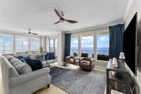 Relax in this modern living room with ocean views through large windows.