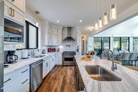 Chef’s kitchen with large island, stainless appliances, and bright lighting