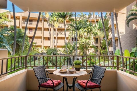 Balcony dining for two overlooking tropical gardens and palms.