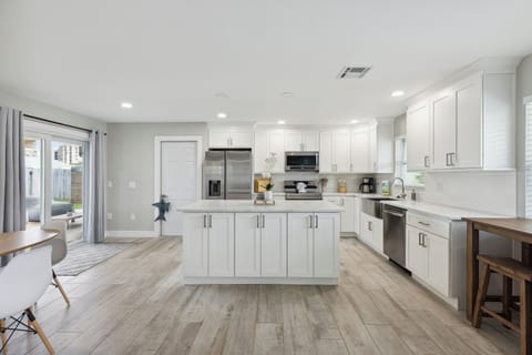 Sleek, modern white kitchen featuring high-end appliances, clean lines, and a bright, airy atmosphere