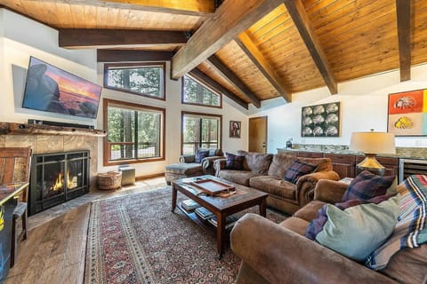 Living Room: Plush furnishings, 55” Smart TV, gas fireplace, wet bar with wine cooler and sink, soaring windows 
