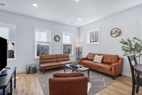 Bright, inviting space with two sleek leather couches, a lounge chair, flat-screen Roku TV, and a dedicated workspace. Great for game nights, movie marathons, or lazy days in.