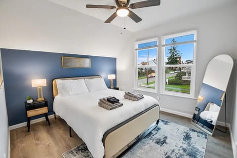 A chic bedroom with modern decor, gold accents, and ample natural light, creating a luxurious ambiance.