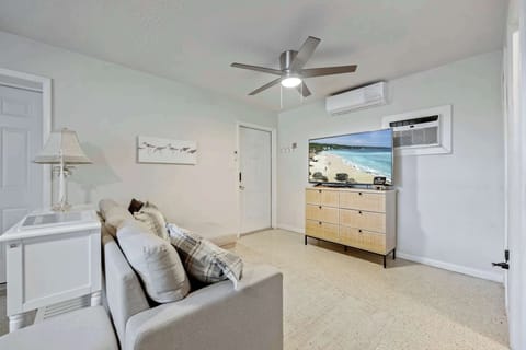 Cozy living area with a modern ceiling fan and large flat-screen TV for relaxing entertainment.