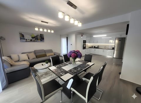 Spacious and modern open-plan living area with a stylish dining set and a comfor