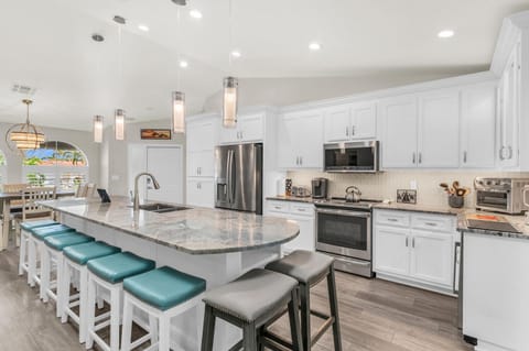 Kitchen is fully stocked with stainless steel appliances, pots, dishes, utensils