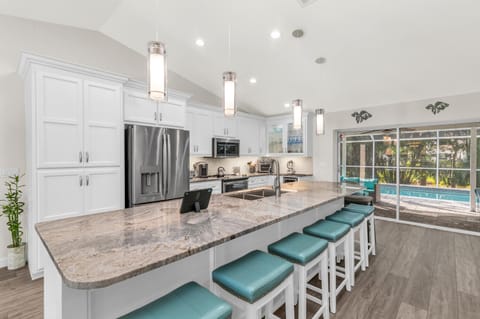 Large granite island w/ seating for 8. Bright, beautiful flow from house to pool