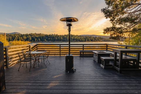 Wide lakefront deck glowing in the evening light, set with plenty of space to dine, gather, and take in the view.