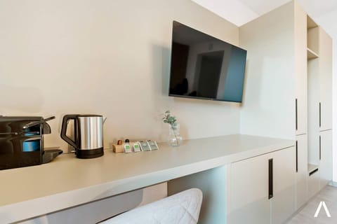 Functional Workspace and Entertainment Area – Wall-mounted TV, small desk, and a cozy chair create a perfect blend of comfort and productivity.