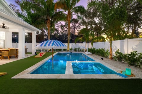 Private backyard oasis with sparkling pool, lush landscaping, and serene evening ambiance