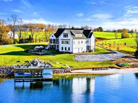 Backyard - Stone patio with firepit seating, plunge pool, and lake views beyond the sloped lawn.