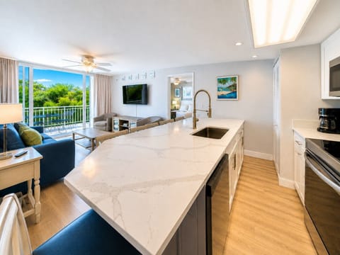 Gather around the oversized island, relax in the open living area, or step onto the private balcony and enjoy the tropical Key West surroundings.