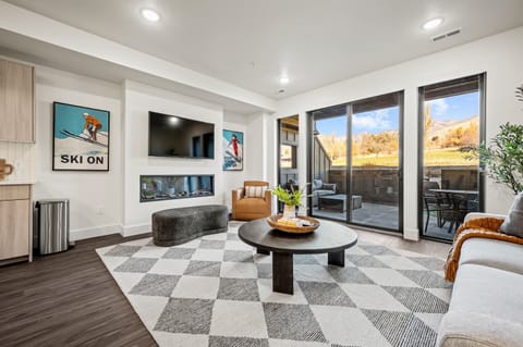 The living room has a large smart TV, electric fireplace, amazing views, and direct access to the deck.