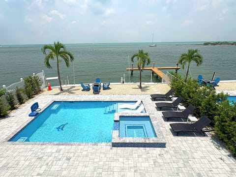 Waterfront Luxury | Heated Pool, Spa & Dock Access Bask in the sun by the serene oceanfront pool. Enjoy the spacious sundeck, jacuzzi, and peaceful views—perfect for families or couples seeking relaxation with luxury finishes.