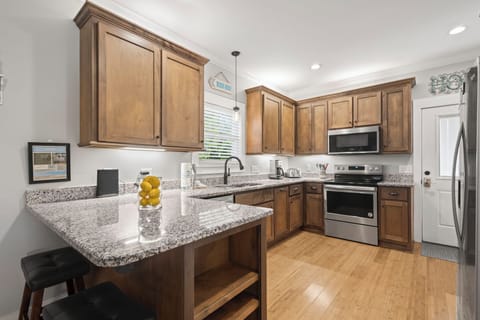 Kitchen - Stainless appliances include a dishwasher, oven, built-in microwave, and refrigerator with ice maker. The cabinets are fully stocked with all items needed for meal prepping during your stay.