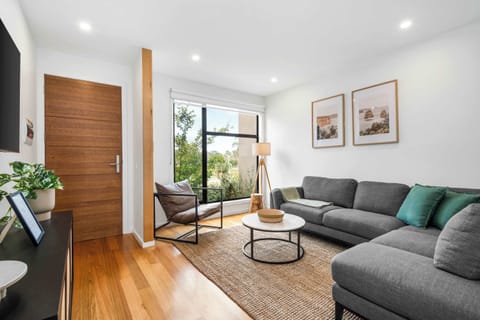 Living room featuring TV, L-shape lounge and stunning wall art.