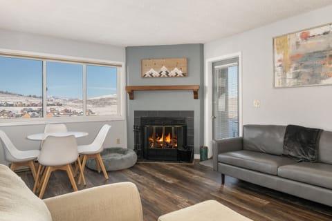 Cozy up by your crackling fireplace at Summit Unit 1103 while taking in breathtaking mountain views through expansive windows in this stylish living space.