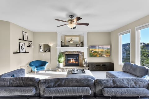 Comfortable Living Room with Fan, Fireplace, and Smart TV view from the Kitchen.