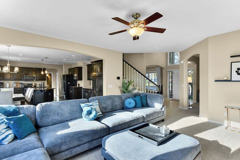 Comfortable Living Room with Fan, Fireplace, and Smart TV View into the Entry, Office, and Kitchen.