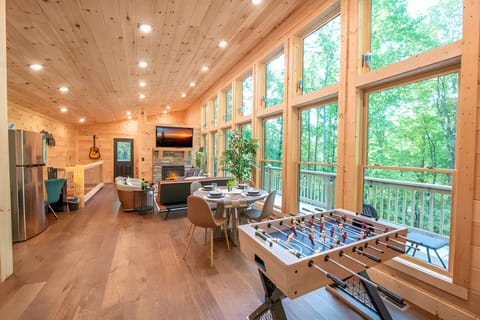 Spacious great room with natural wood throughout, floor-to-ceiling windows,