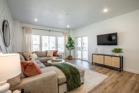 Bright open-concept living and dining space with mid-century touches, modern lighting, and plenty of natural light—perfect for gathering after exploring American Fork Canyon.