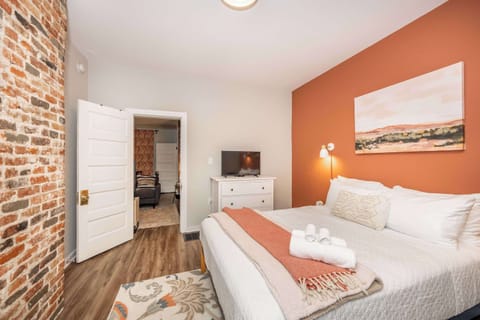 A plush queen bed & smart TV await in the first bedroom sanctuary
