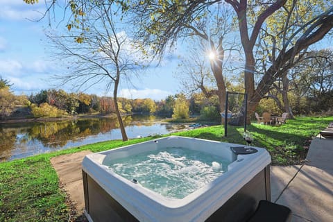 Jacuzzi overlooking a serene lake with stunning panoramic views.