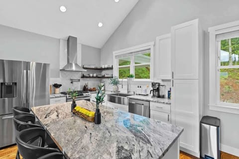 Modern kitchen with spacious island, natural light, and mountain views.