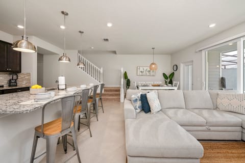 The living room, kitchen, and dining area seamlessly blend into one open space, creating the perfect setting for socializing during the holidays.