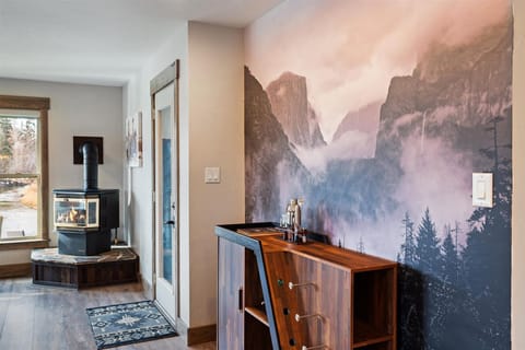 Sip and relax at the custom bar with a stunning nature mural backdrop, adding a touch of mountain charm to your evenings.