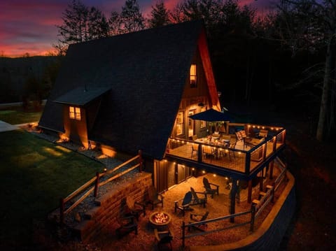 The spacious deck, fire pit, and ambient lighting create an inviting atmosphere for relaxation and entertainment.