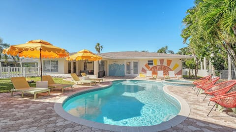 The tropical backyard offers a heated saltwater pool and hot tub/spa for guests to enjoy. A firepit sits perfectly between the main house and guest house, making it an inviting spot for evenings. 