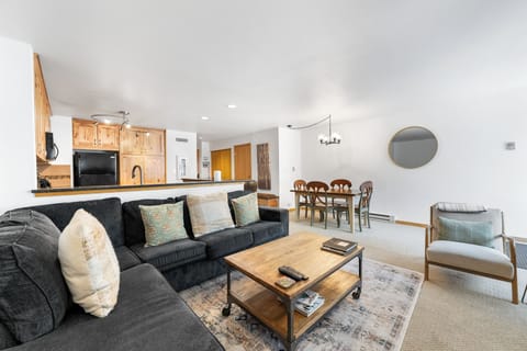 Living area with TV, queen sleeper sofa, fireplace, and balcony access.